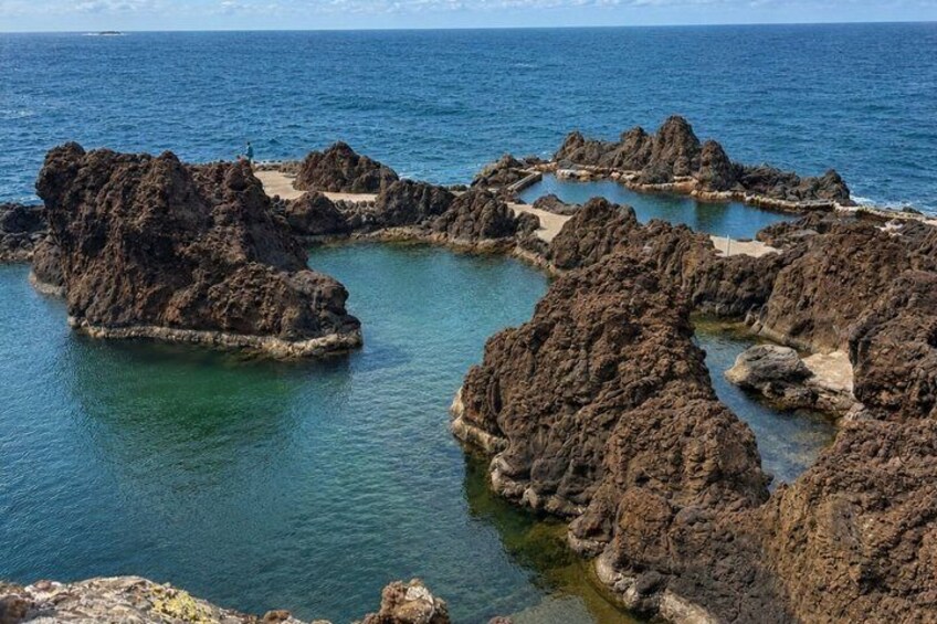 A coastal landscape with rocky formations and clear blue water. 4