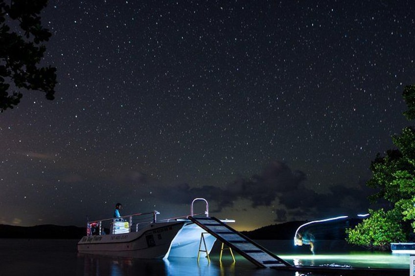 Un barco atracado de noche bajo un cielo estrellado. 1