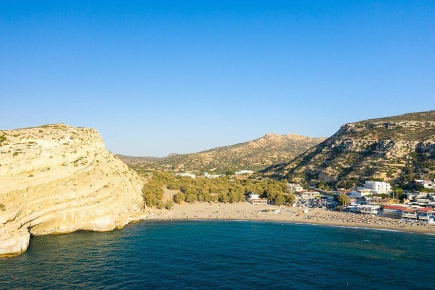 Een kustplaatsje met een strand, kliffen en een heldere blauwe zee. 3