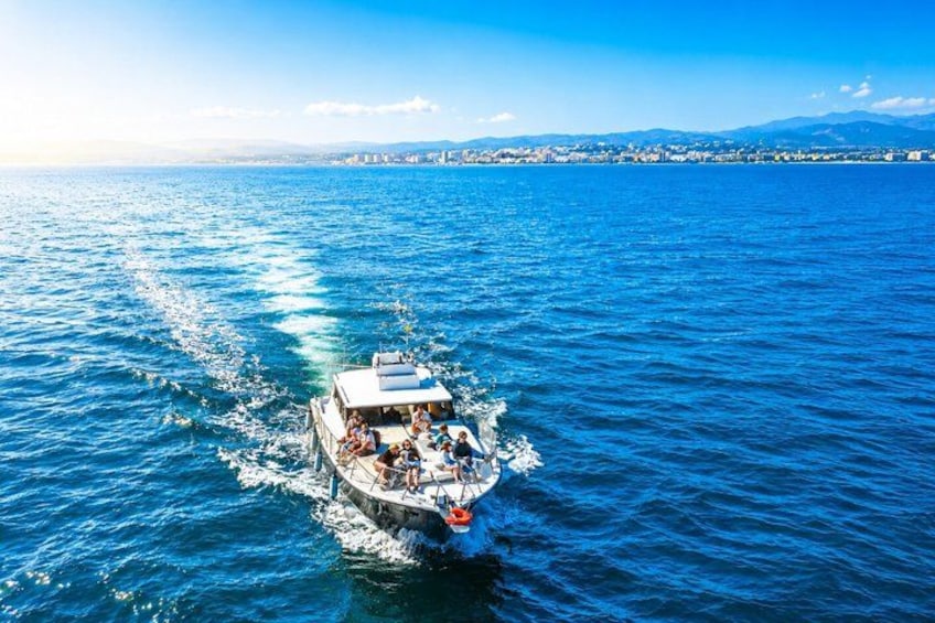 A boat on a blue sea with a cityscape in the background. 5