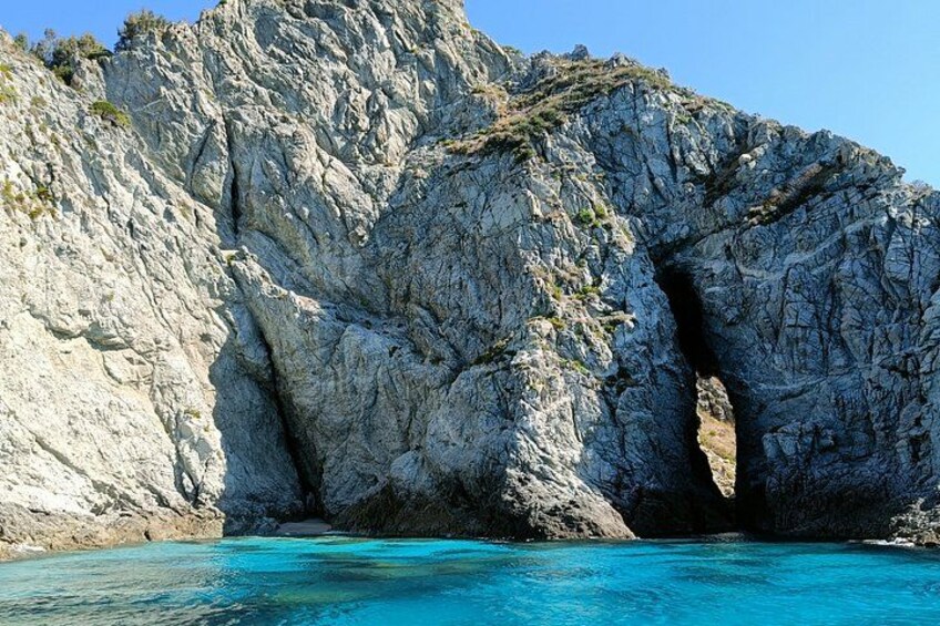 A rocky coastline with a natural arch formation. 2