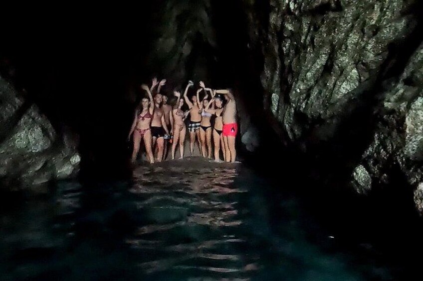 A group of people in a cave with water at the bottom. 3