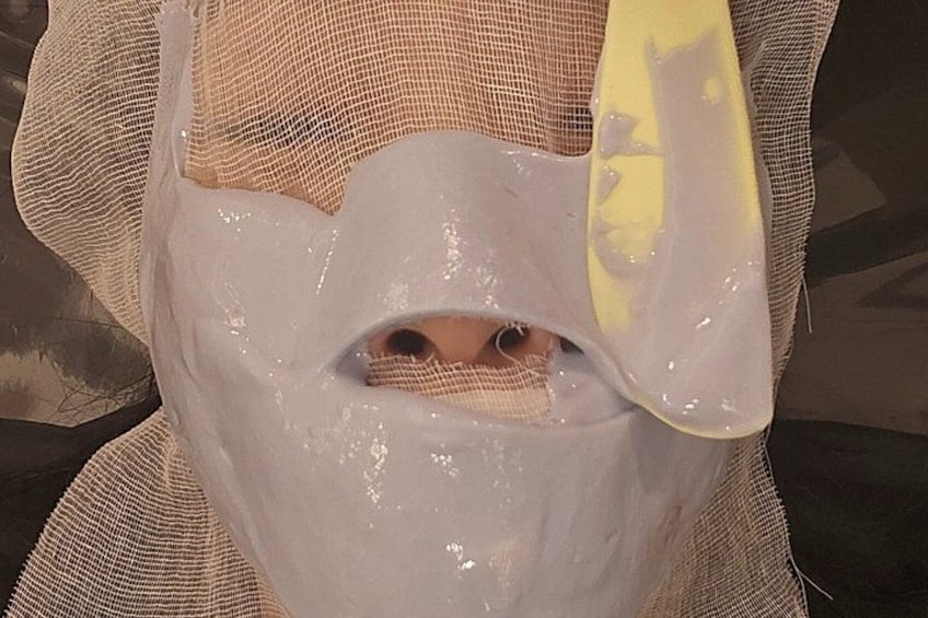 A person wearing a mesh head covering with a yellow object. 2