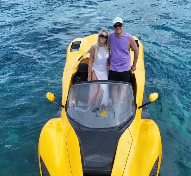 A yellow boat with two people on it, floating on clear blue water. 3