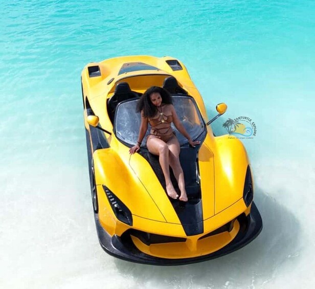 A woman sitting in a yellow car on a beach. 1