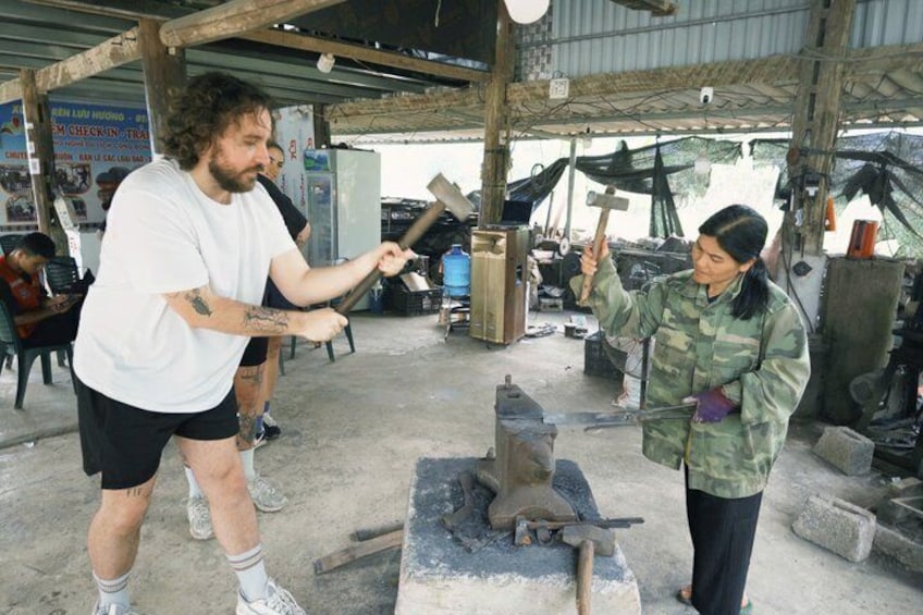 Two people working with a forge and an anvil in a workshop. 3