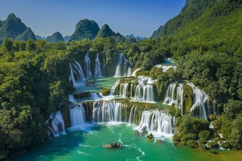A multi-tiered waterfall surrounded by lush greenery and mountains. 1
