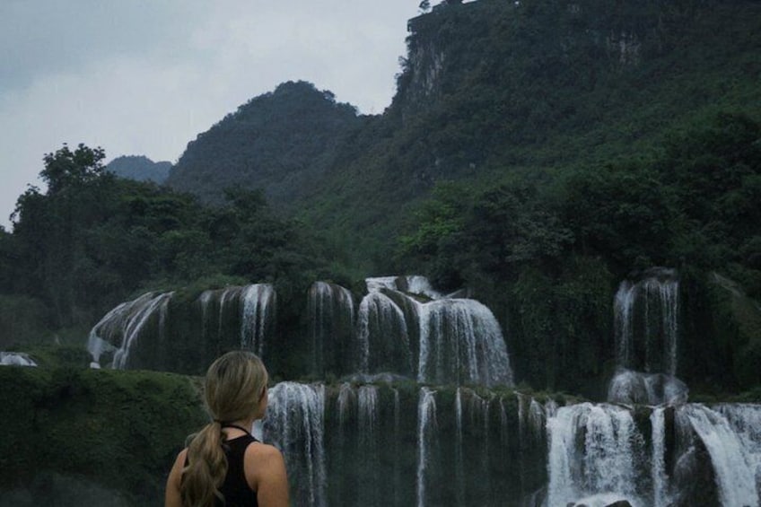 A waterfall cascading over a cliff with dense forest in the background. 2