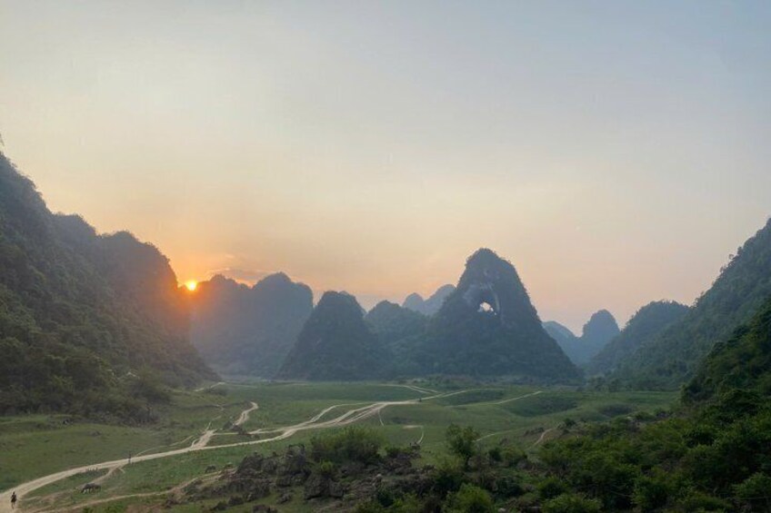 A mountainous landscape with a winding road and a prominent rock formation. 5