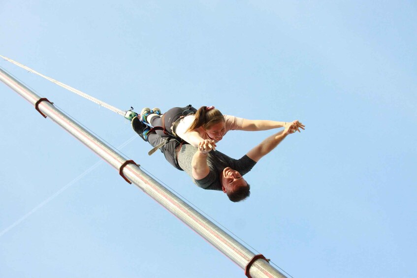 A person bungee jumping with a harness and safety gear. 1