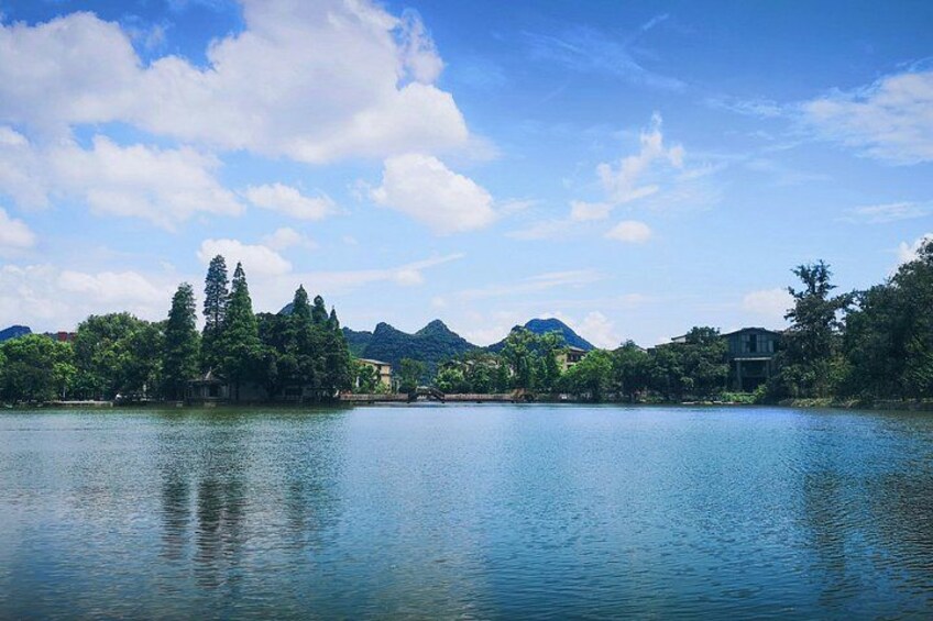A calm lake with mountains in the background and trees along the shore. 5