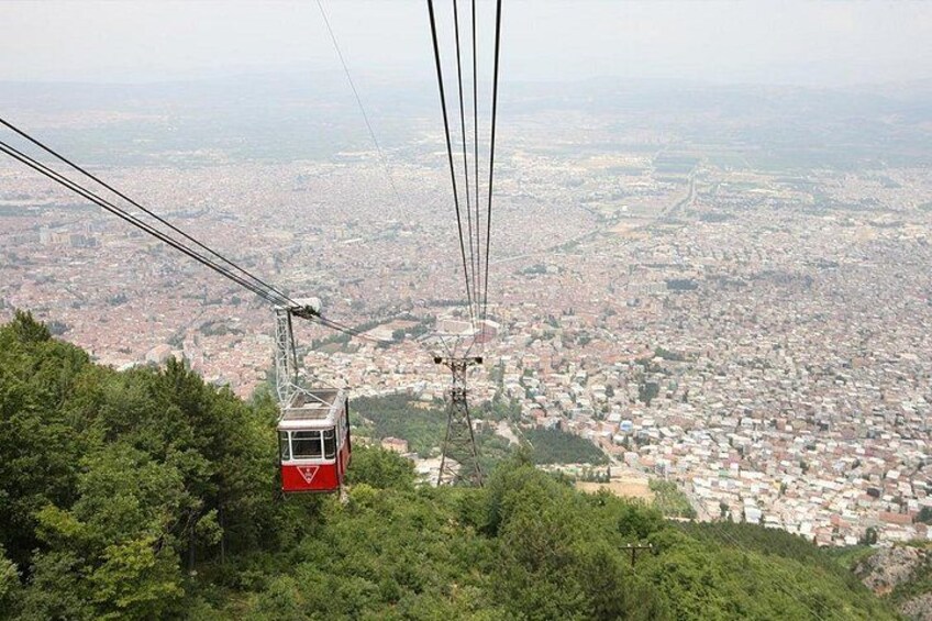 A cable car moving along a cable, with a cityscape in the background. 3