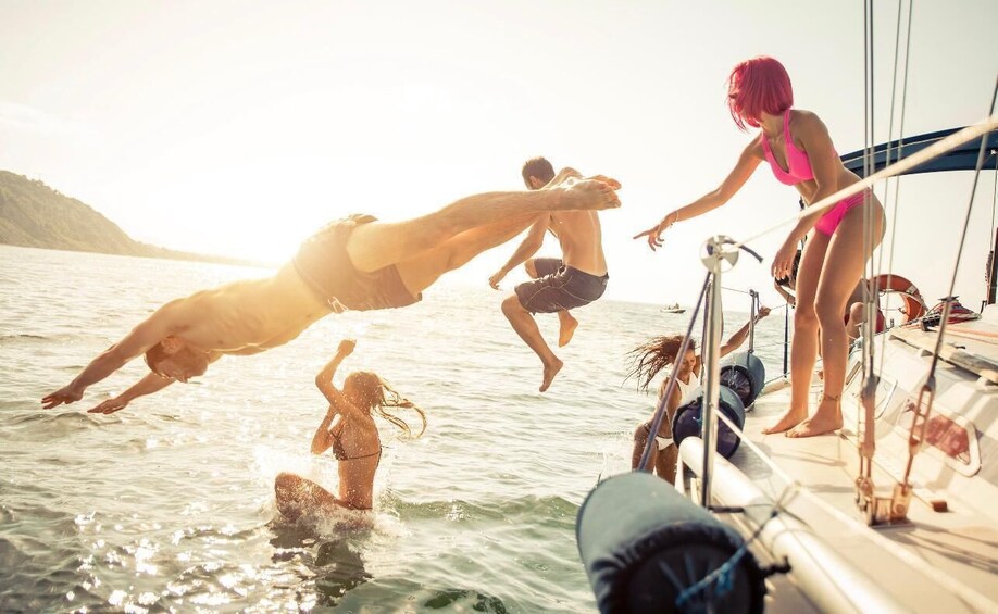 People jumping off a boat into the water. 3
