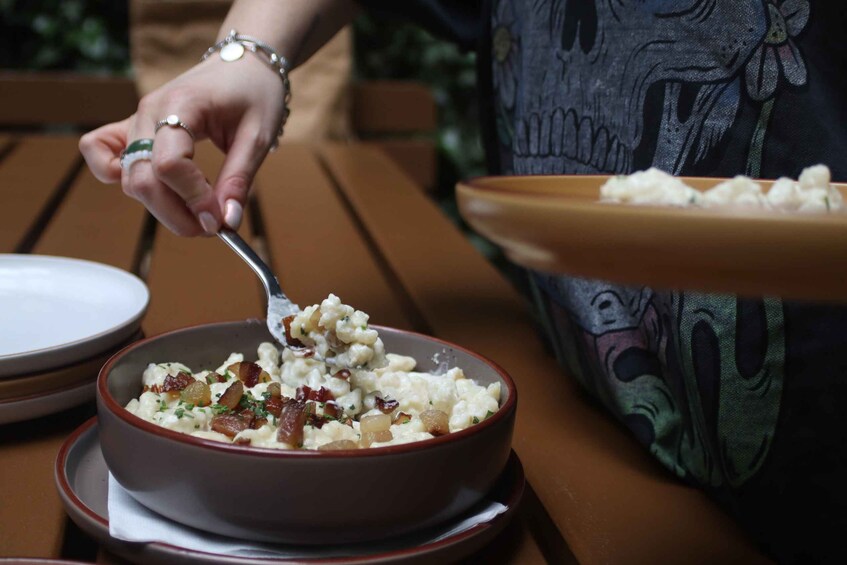 A person eating a bowl of food with a spoon. 4