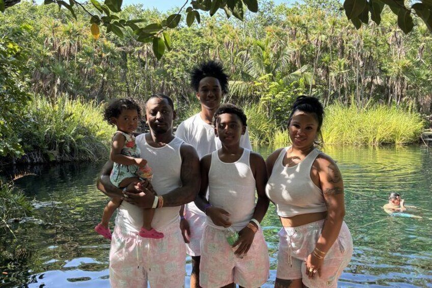 Un grupo de personas junto a un río tranquilo rodeado de abundante vegetación. 2