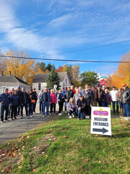 A group of people standing in front of a sign that reads 'Albert County Museum Entrance.' 2
