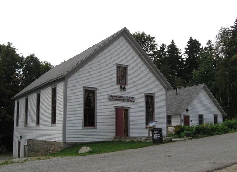 A white building with a red door labeled 'Hopewell Cape Community Hall.' 5
