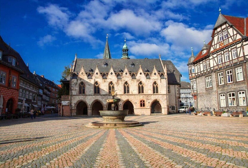 A historic building with a central courtyard, a fountain, and surrounding cobblestone pavement. 5