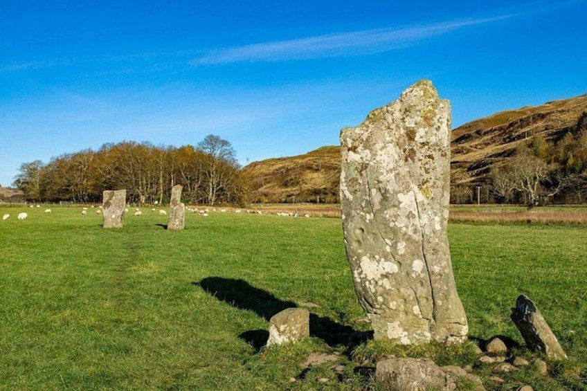 Standing stones in a grassy field with hills in the background. 2