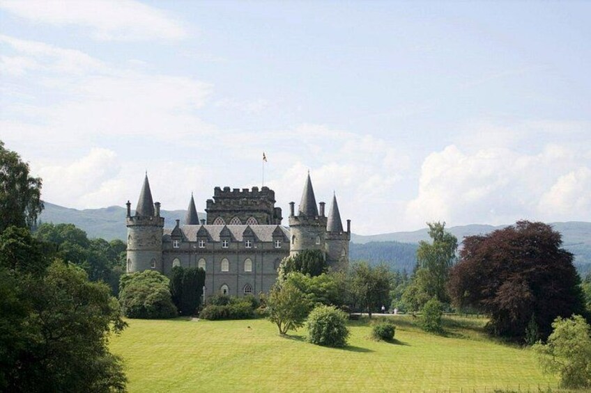 A castle with multiple towers, surrounded by lush green fields and trees. 3