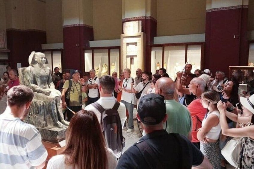 A crowd gathered around a large statue in an indoor setting. 5