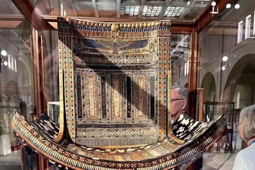 A richly decorated ancient chair with intricate patterns and a golden frame. 2