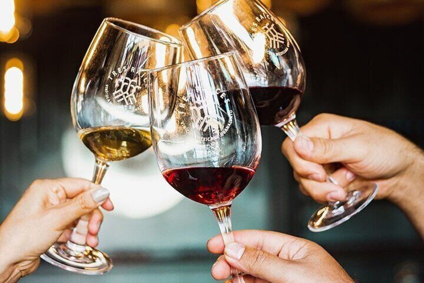 Tre mani che reggono calici di vino rosso e bianco, in un brindisi. 3