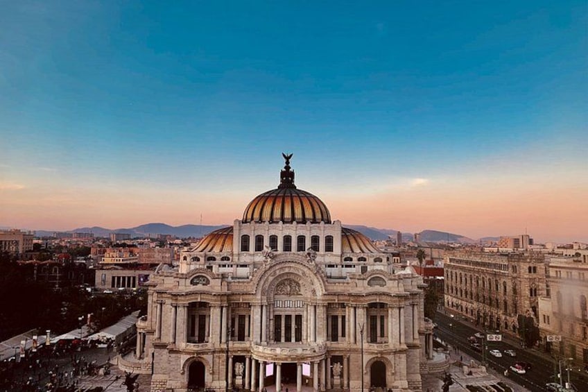 A large, ornate building with a prominent dome and columns, surrounded by a cityscape. 1