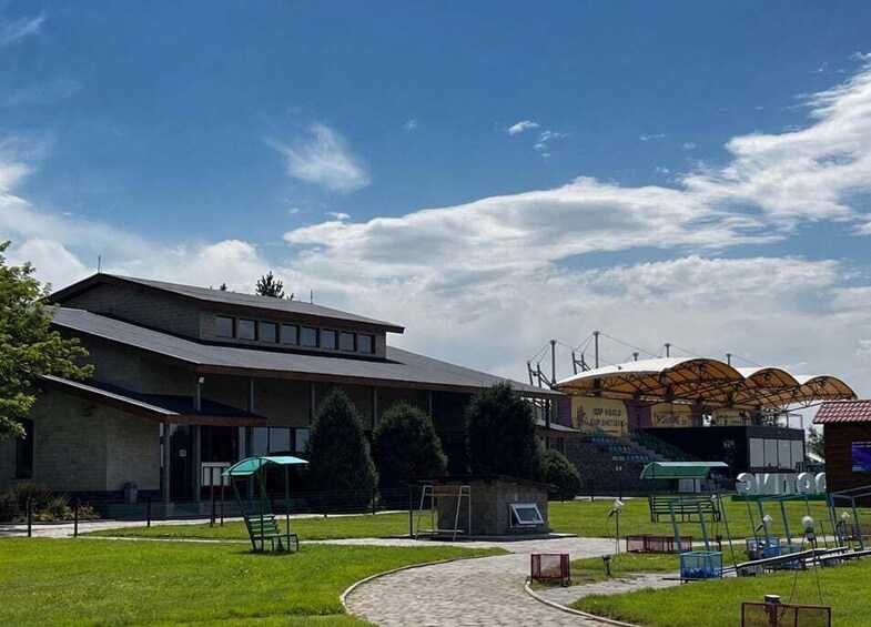 A building with a modern design, a covered sports area, and a green lawn. 5