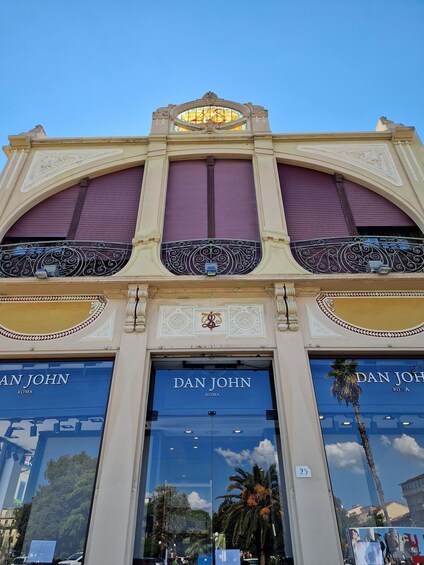 A building facade with ornate architectural details, including a large arched window and decorative metalwork. 1