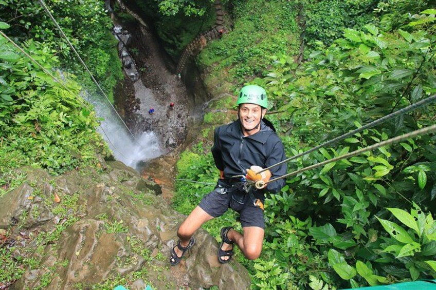 Una persona haciendo bungee jumping desde un acantilado con una cascada debajo. 1