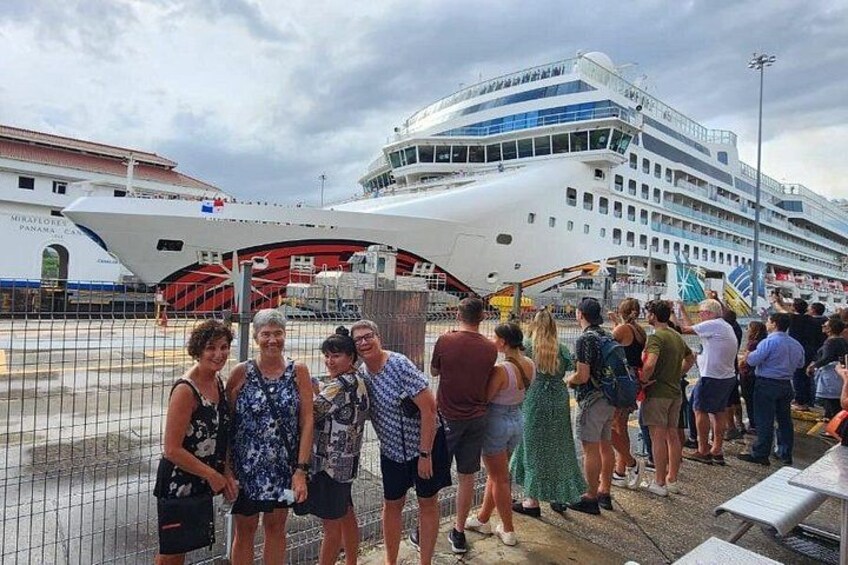 A cruise ship docked at a port with people standing on the dock. 4