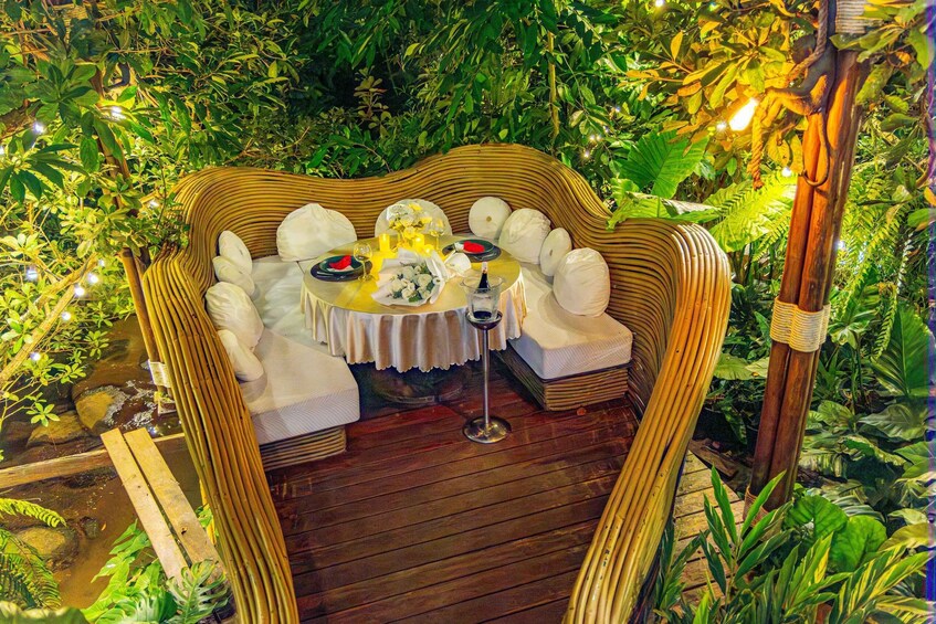 An outdoor dining area with a round table, white chairs, and a wicker sofa. 5