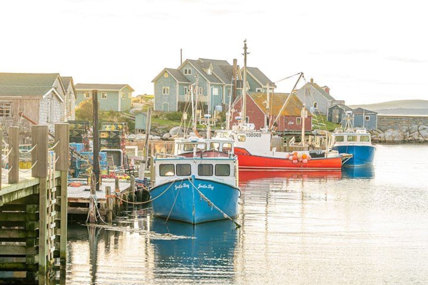 A harbor with boats docked, wooden structures, and houses in the background. 5