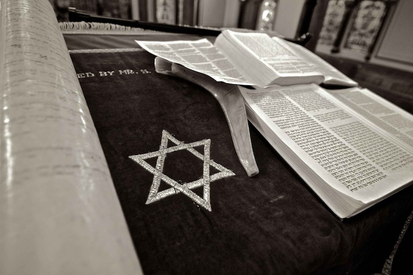 A book with a Star of David on a dark surface, alongside another open book. 2