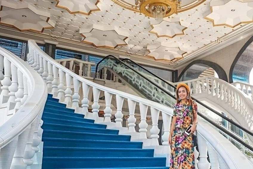 A grand staircase with blue steps, white balustrades, and a decorative ceiling. 1