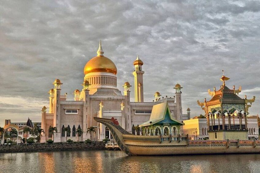 A large mosque with a golden dome and minarets, a boat, and a traditional pavilion. 5
