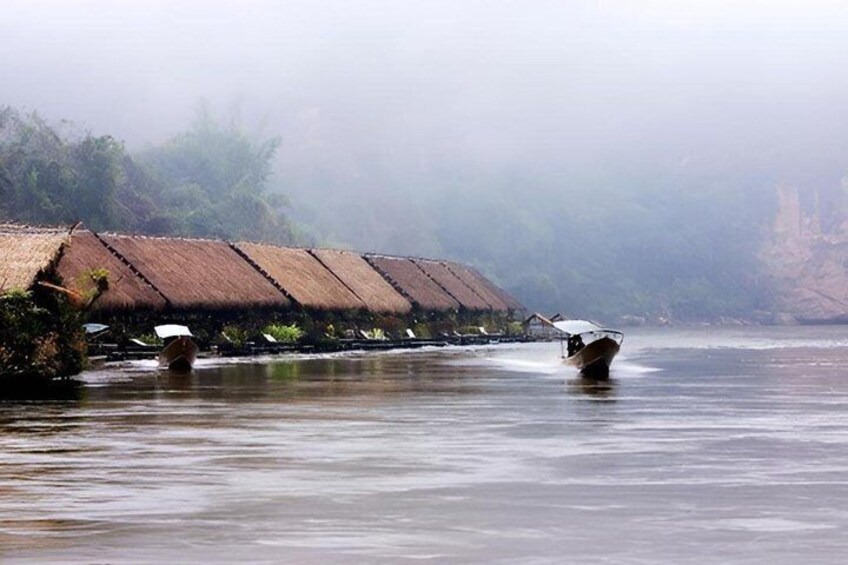 A river with boats, a row of thatched-roof huts, and a misty landscape. 4