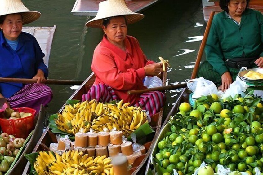 Three people in a boat with various fruits like bananas and limes. 1