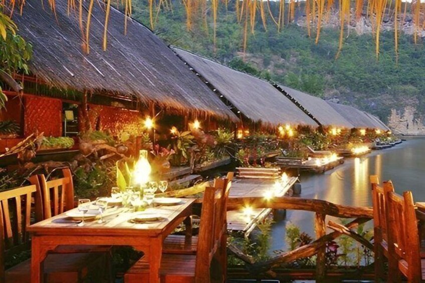 A restaurant with thatched roofs by a calm body of water. 2