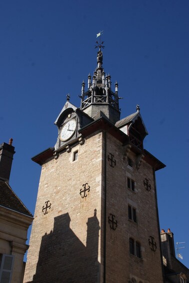 A historic tower with a clock and crosses on its facade. 2