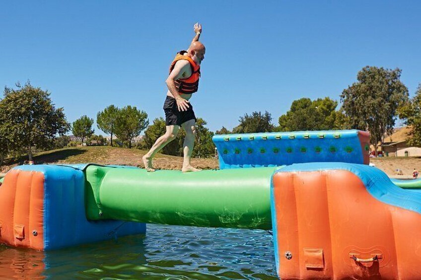 A person walking on a floating platform in a body of water. 3