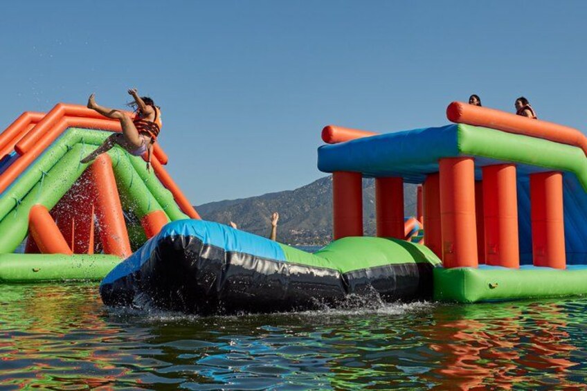 Een opblaasbaar waterpark met glijbanen en een zwembad. 5