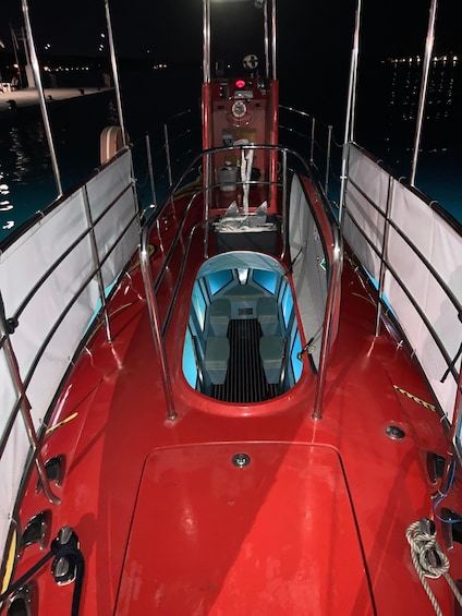 A boat deck with a central steering wheel, railings, and a blue cockpit area. 5
