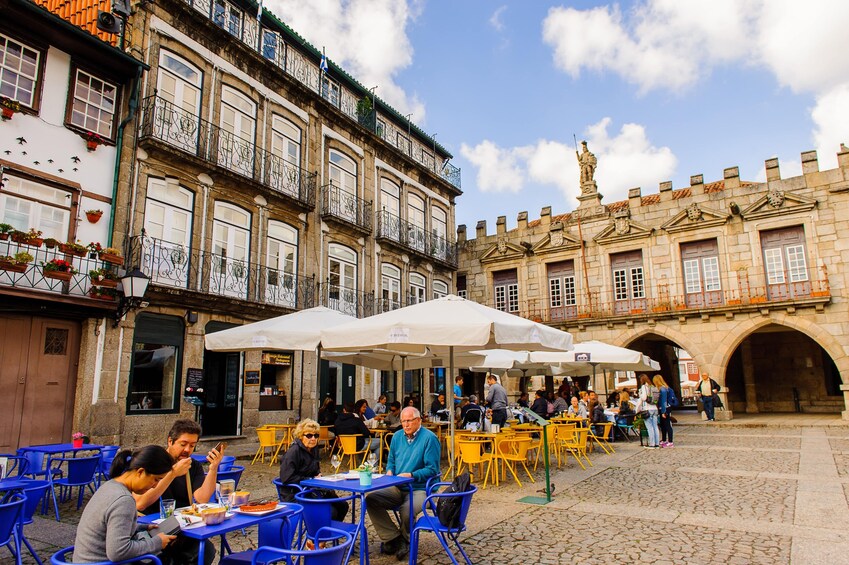 Un café animé en plein air, où les gens prennent leurs repas et discutent. 5