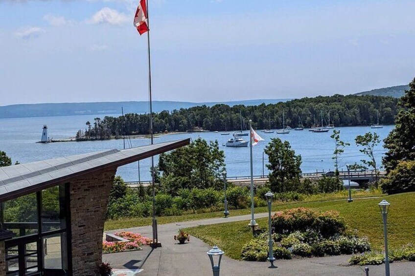 A waterfront view with a flag, boats, and a distant lighthouse. 1