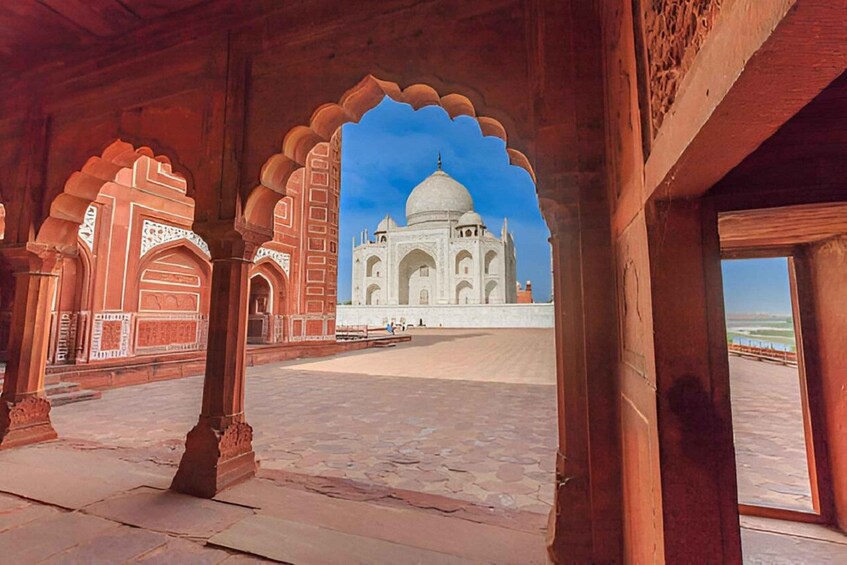 An interior view with a large archway leading to the Taj Mahal. 1