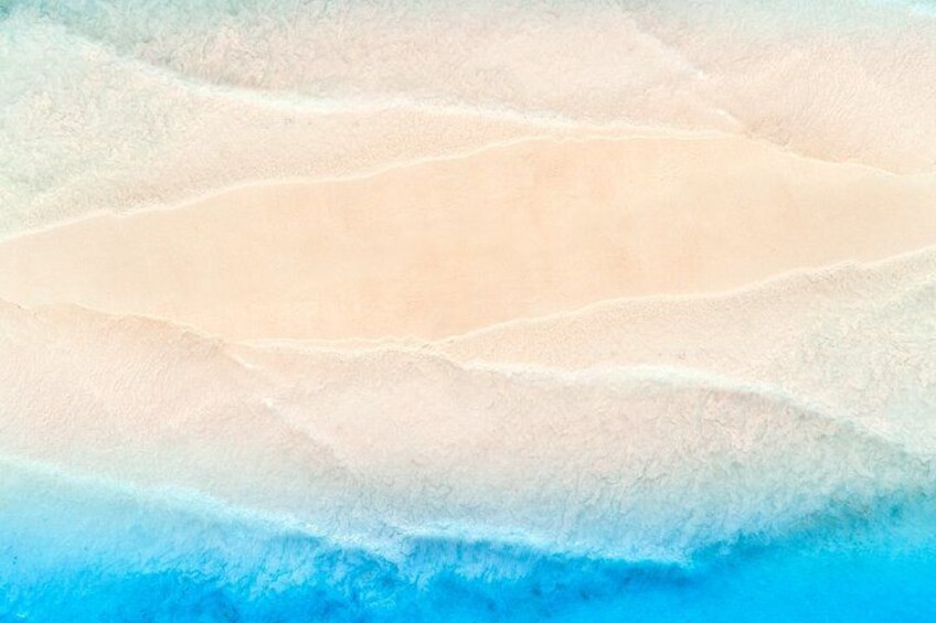 Une plage avec des dunes de sable en terrasses et une ligne de rivage d’un bleu limpide. 5