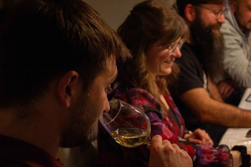 A person holding a glass of white wine. 3