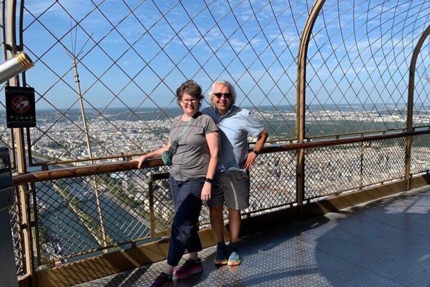Two people standing on a bridge with a cityscape in the background. 2
